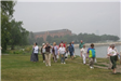 Group Standing in the Grass with Building in the Distance