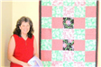 Woman Standing Next to Red and Green Quilt