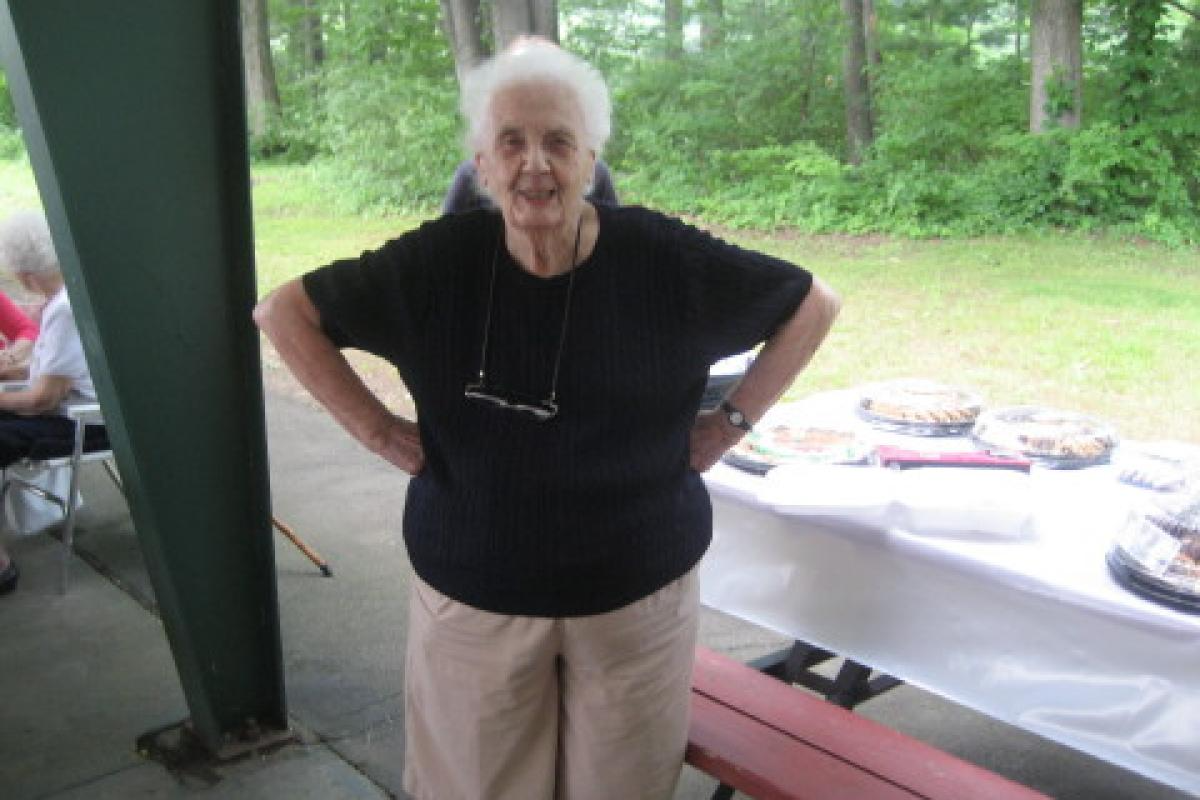 Woman Smiling Next to Picnic Table