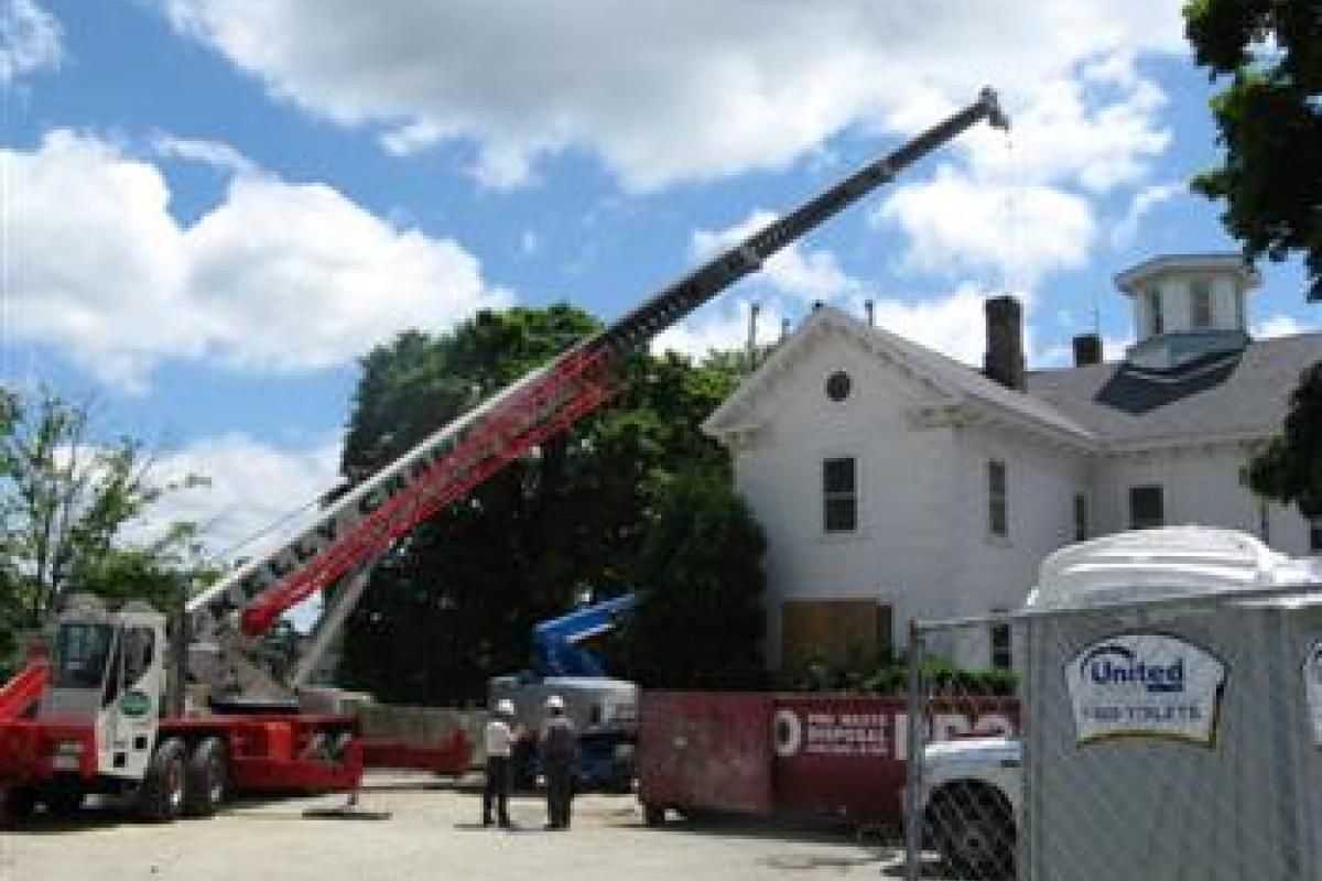 Workers and a Crane in Front of Building